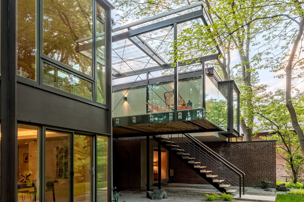 Esempio di una piccola terrazza moderna dietro casa e al primo piano con parapetto in vetro