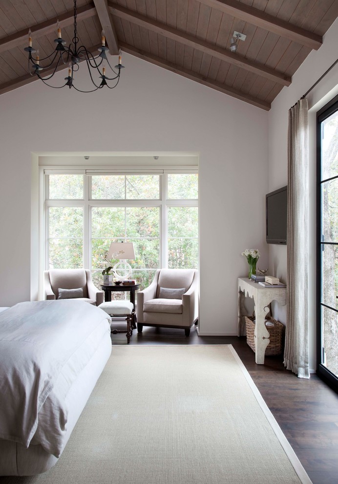 Design ideas for a mediterranean master bedroom in Austin with white walls and dark hardwood floors.