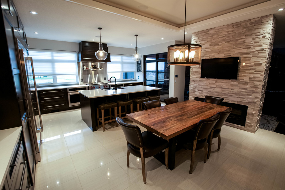 Photo of an expansive industrial l-shaped eat-in kitchen in Other with a drop-in sink, dark wood cabinets, granite benchtops, grey splashback, stainless steel appliances and with island.