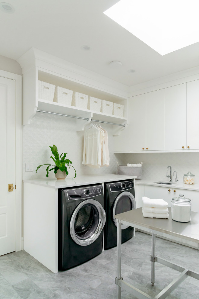 Inspiration for a large transitional u-shaped utility room in Other with an undermount sink, flat-panel cabinets, white cabinets, quartzite benchtops, white splashback, ceramic splashback, grey walls, vinyl floors, a side-by-side washer and dryer, grey floor and grey benchtop.
