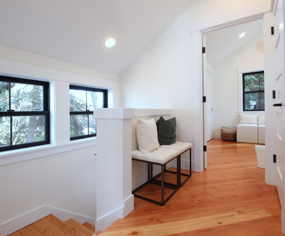 Inspiration for a small craftsman light wood floor and vaulted ceiling hallway remodel in Seattle with white walls