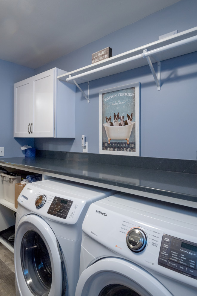 This is an example of a large transitional l-shaped laundry room in Other with an undermount sink, shaker cabinets, yellow cabinets, quartz benchtops, vinyl floors, brown floor and brown benchtop.