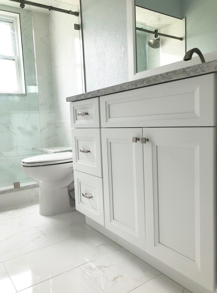 Mid-sized transitional 3/4 bathroom in Tampa with recessed-panel cabinets, white cabinets, an alcove shower, a one-piece toilet, white tile, porcelain tile, beige walls, porcelain floors, an undermount sink, engineered quartz benchtops, white floor, a sliding shower screen and grey benchtops.