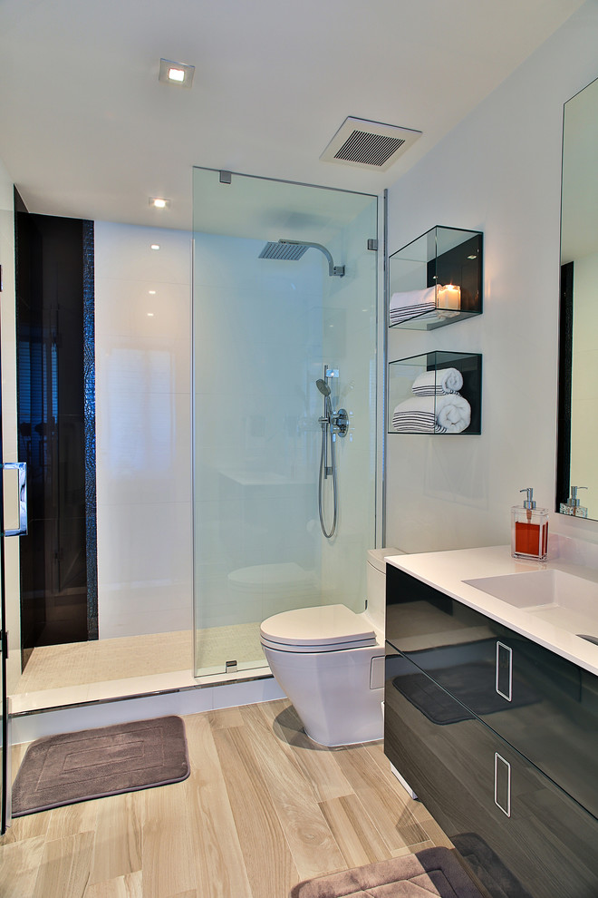 This is an example of a large contemporary 3/4 bathroom in Miami with an undermount sink, flat-panel cabinets, medium wood cabinets, an open shower, a one-piece toilet, white tile, porcelain tile, white walls and porcelain floors.