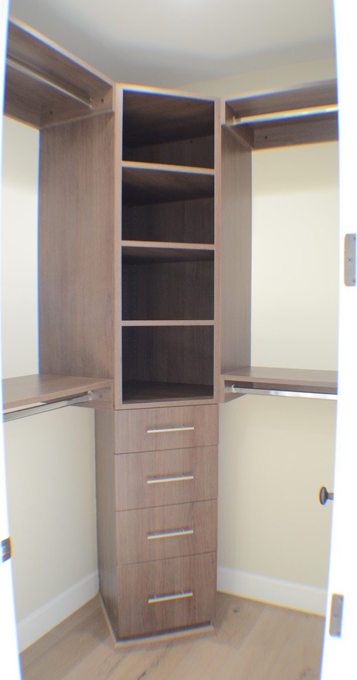 Photo of a small traditional gender-neutral walk-in wardrobe in Los Angeles with open cabinets, brown cabinets, light hardwood floors and brown floor.
