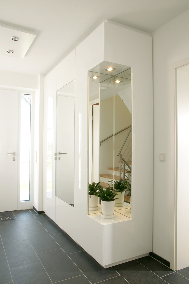 Photo of a mid-sized contemporary hallway in Other with white walls, laminate floors and black floor.