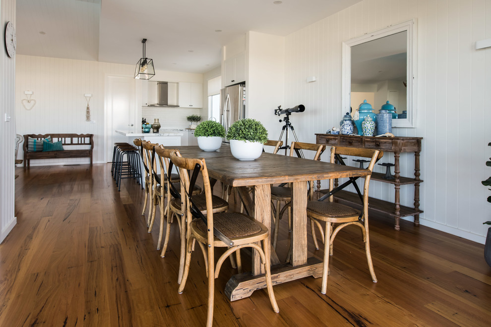 Beach style open plan dining in Melbourne with white walls, medium hardwood floors and brown floor.