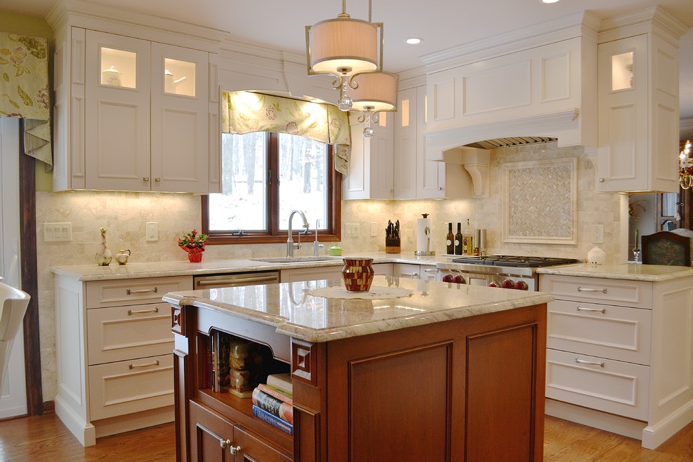Inspiration for a mid-sized traditional u-shaped eat-in kitchen in New York with an undermount sink, recessed-panel cabinets, white cabinets, marble benchtops, beige splashback, porcelain splashback, panelled appliances, medium hardwood floors, with island, brown floor and beige benchtop.