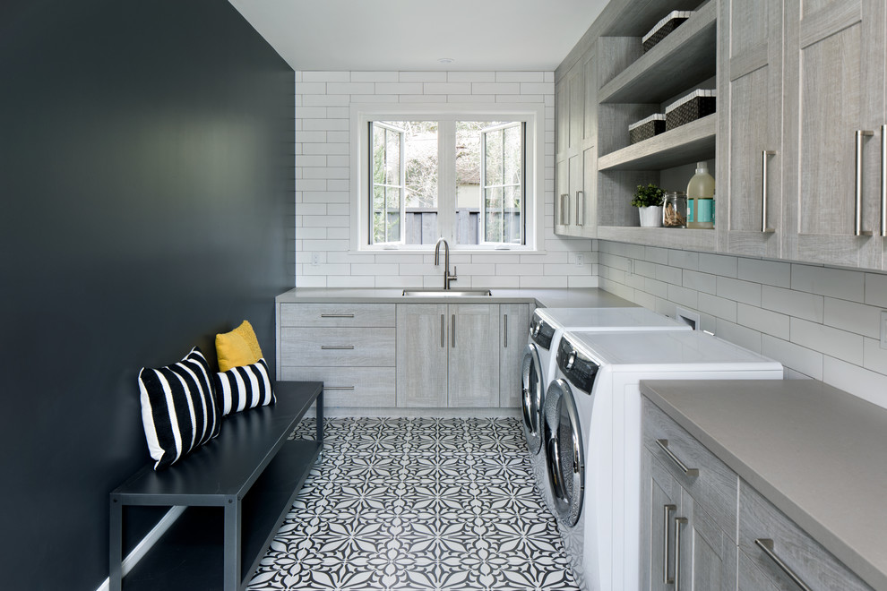 Country laundry room in San Francisco with a side-by-side washer and dryer, an undermount sink and black walls.
