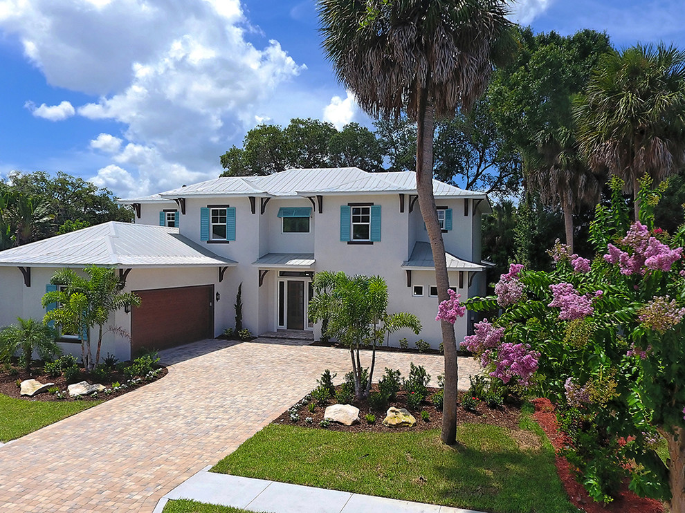 This is an example of a large transitional two-storey stucco white exterior in Tampa with a hip roof.