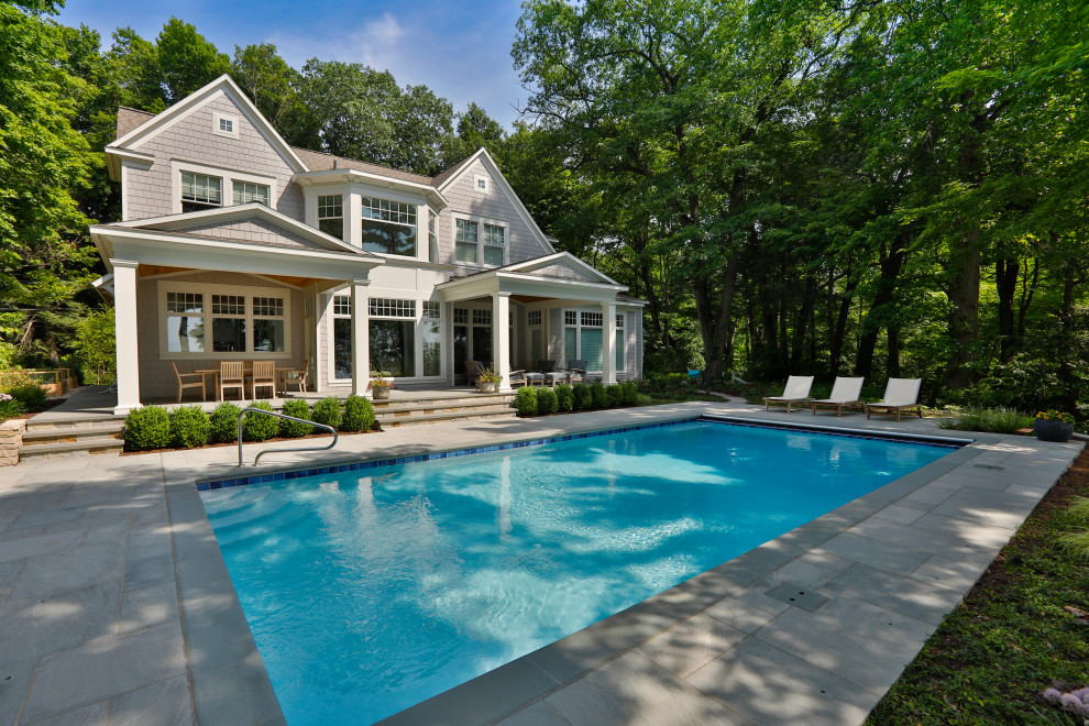 Diseño de piscina alargada tradicional de tamaño medio rectangular en patio trasero con privacidad y adoquines de piedra natural