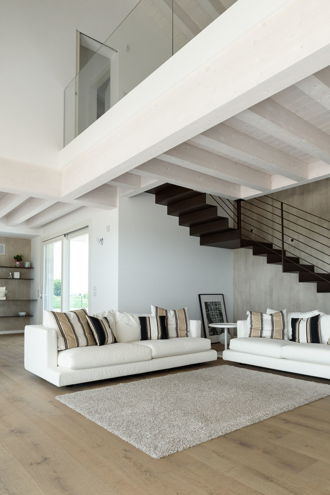 Photo of a large contemporary open concept family room in Venice with white walls and light hardwood floors.