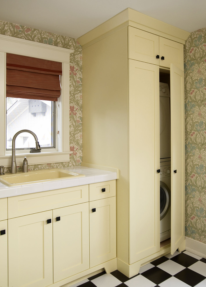 Traditional laundry room in Toronto with a concealed washer and dryer.