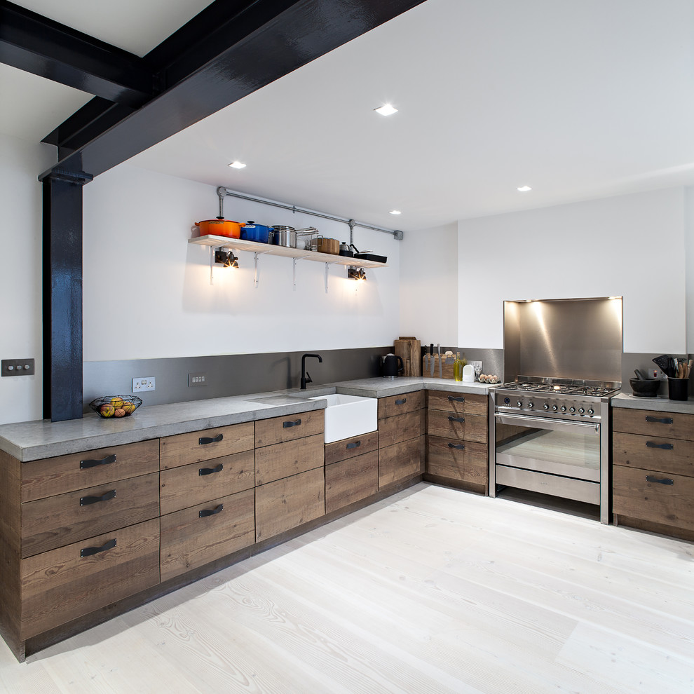 Photo of a contemporary l-shaped kitchen in London with a farmhouse sink, flat-panel cabinets, medium wood cabinets, concrete benchtops, metallic splashback, metal splashback, stainless steel appliances and light hardwood floors.