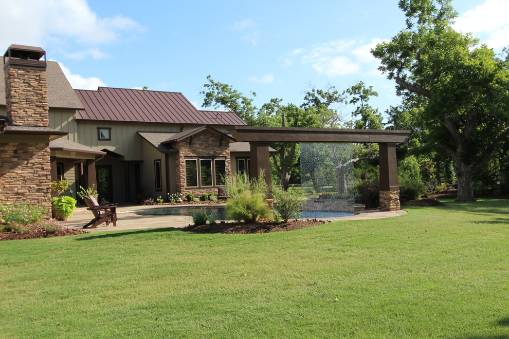 Example of a large mountain style backyard tile and custom-shaped pool fountain design in Houston