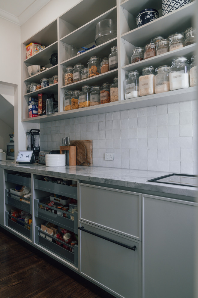 Foto di una grande cucina minimalista con lavello sottopiano, ante in stile shaker, ante grigie, top in granito, paraspruzzi grigio, paraspruzzi in granito, elettrodomestici neri, parquet scuro, pavimento marrone e top grigio