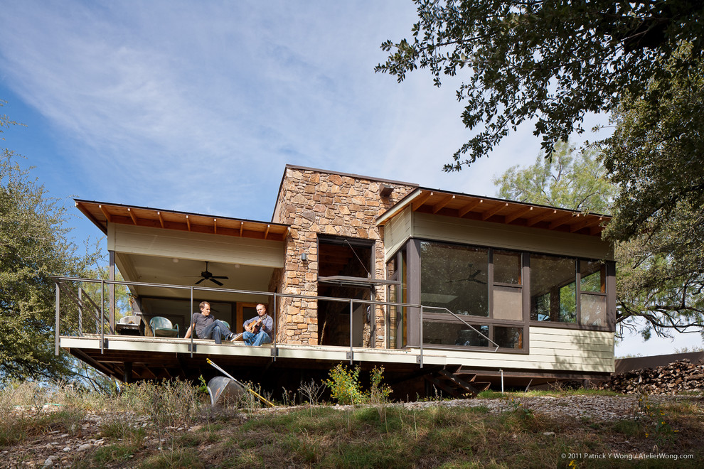 Photo of a mid-sized modern one-storey beige exterior in Austin with mixed siding and a flat roof.