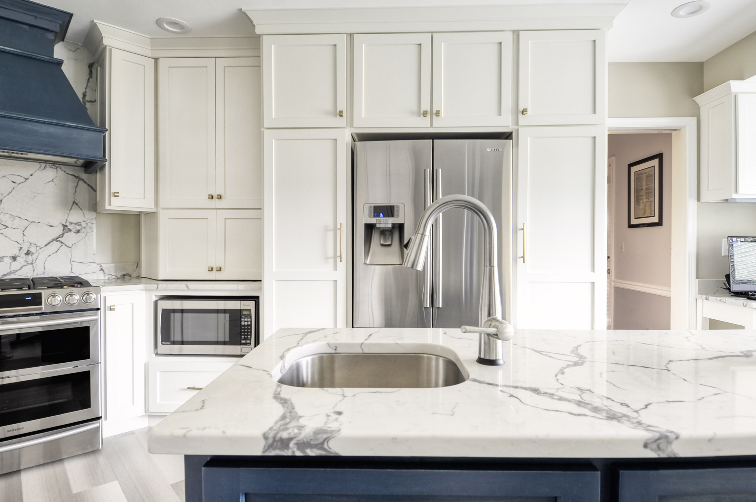 Navy Stained Island, Hood vent and Floating Shelves in White Shaker Kitchen