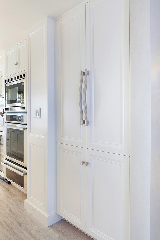 Inspiration for a mid-sized transitional light wood floor and beige floor kitchen remodel in Miami with white cabinets and recessed-panel cabinets