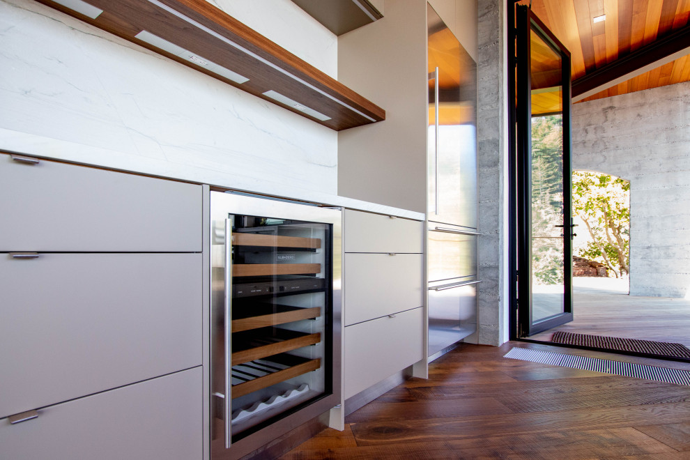 Diseño de cocina urbana grande con armarios con paneles lisos, puertas de armario beige, suelo marrón, encimeras multicolor y vigas vistas