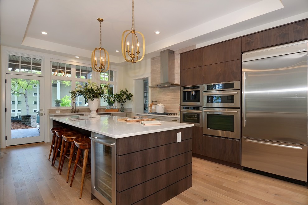 Photo of a transitional open plan kitchen in Vancouver with flat-panel cabinets, dark wood cabinets, beige splashback, stainless steel appliances, medium hardwood floors and with island.