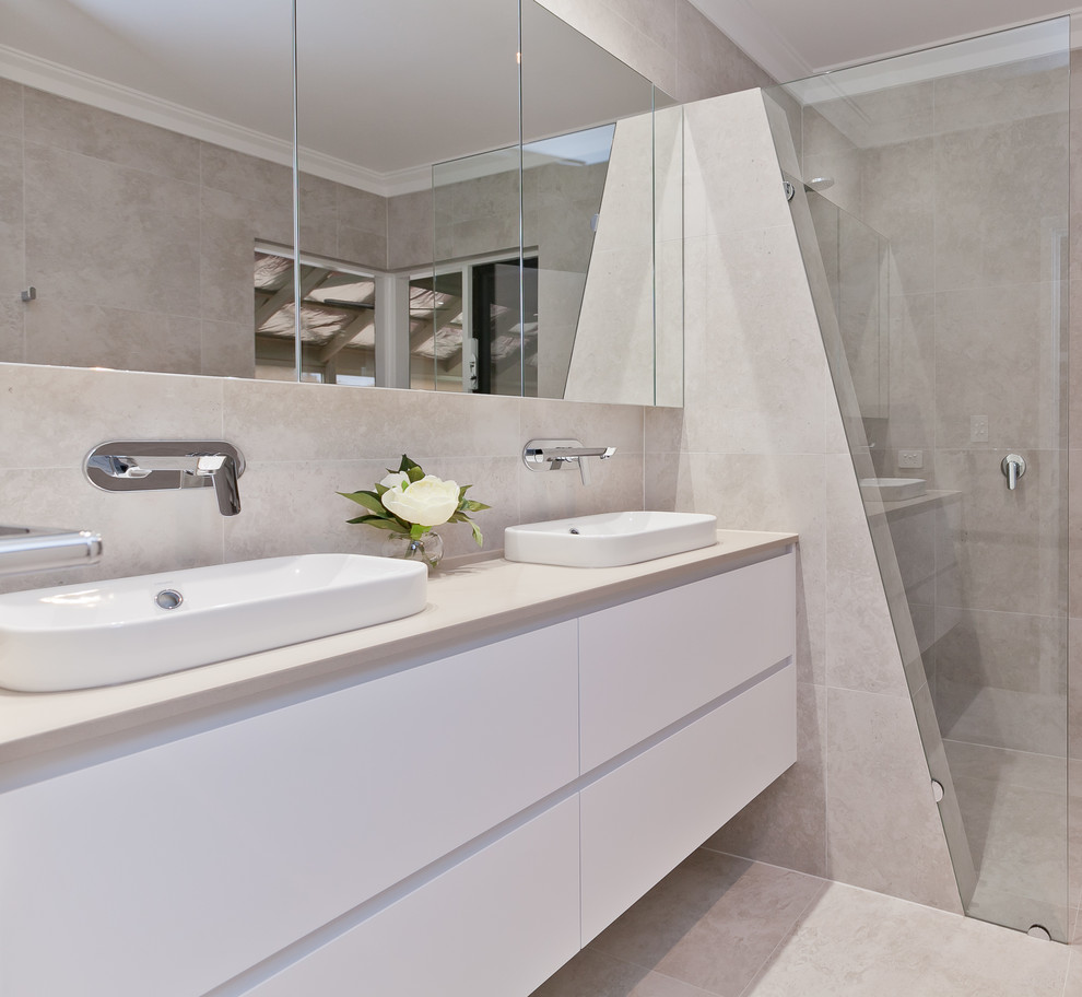 Mid-sized contemporary master bathroom in Perth with flat-panel cabinets, white cabinets, a drop-in tub, an open shower, a one-piece toilet, beige tile, porcelain tile, a drop-in sink, engineered quartz benchtops and beige benchtops.