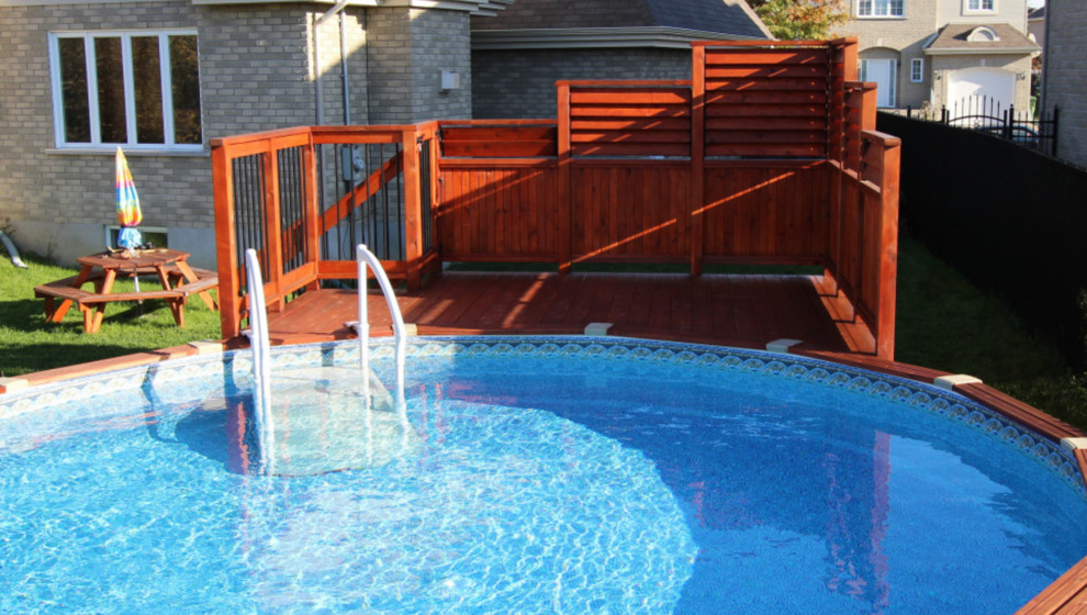 Inspiration for a mid-sized arts and crafts backyard round aboveground pool in Montreal.