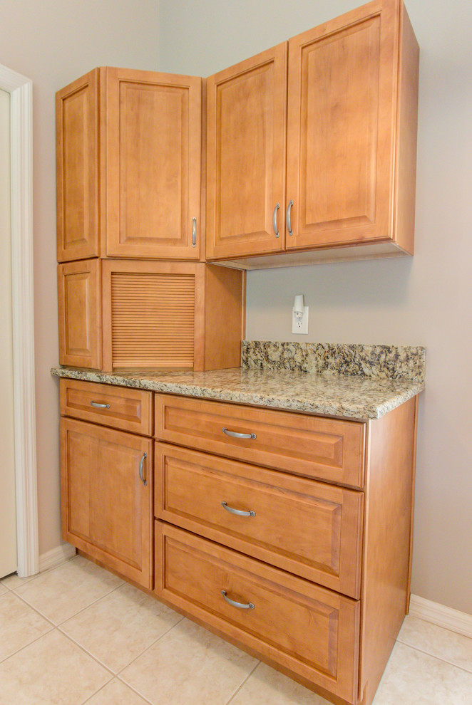 Example of a mid-sized kitchen design with an undermount sink, raised-panel cabinets, medium tone wood cabinets, granite countertops, white appliances and brown countertops