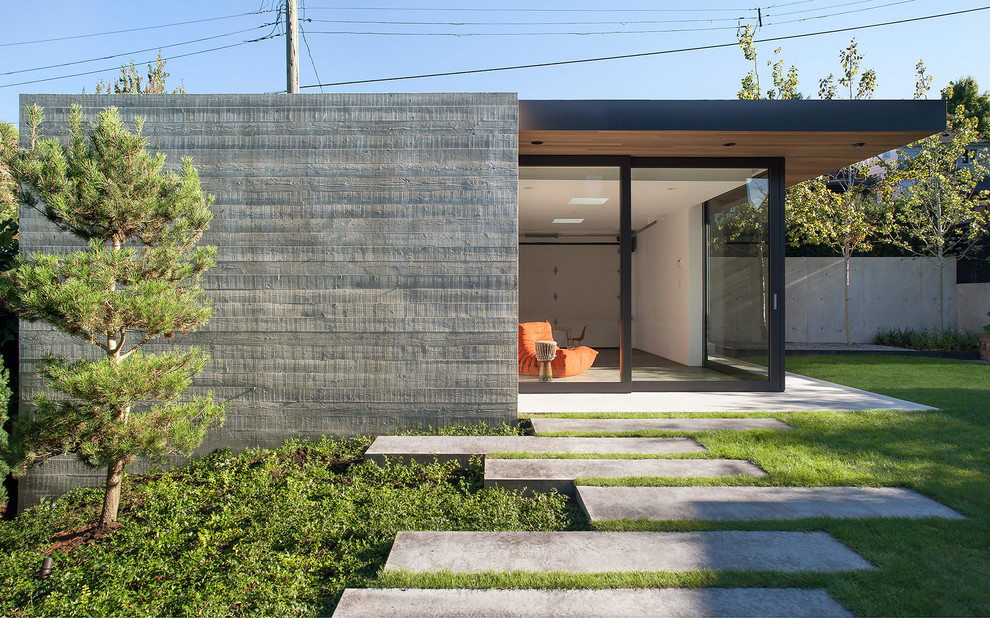 This is an example of a small contemporary one-storey concrete exterior in Vancouver with a flat roof.