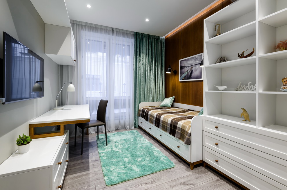 This is an example of a contemporary kids' room for girls in Moscow with light hardwood floors.