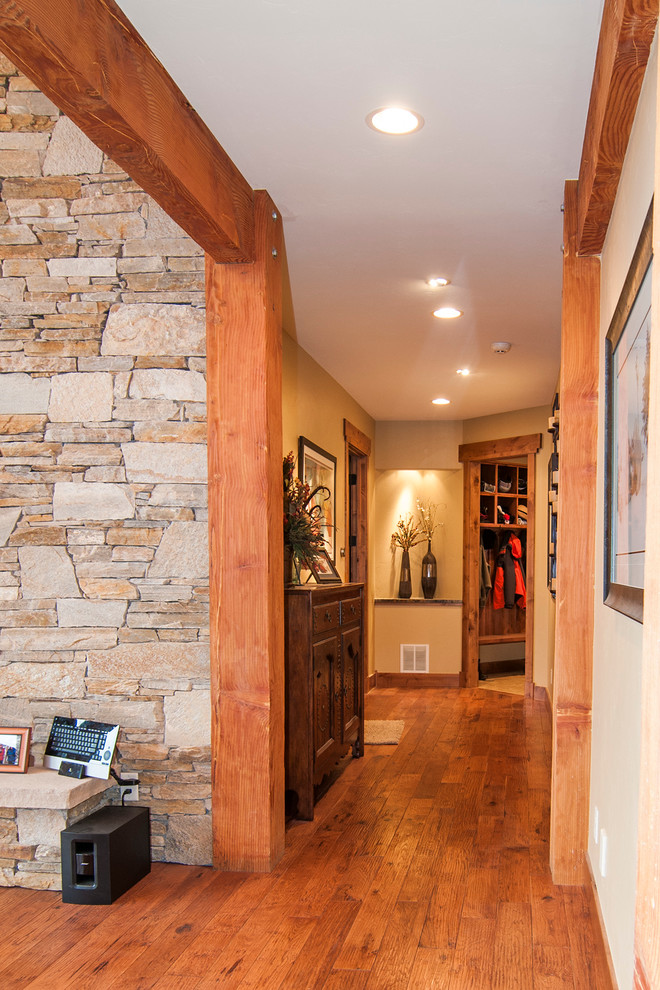 Photo of a large country hallway in Denver with beige walls and medium hardwood floors.