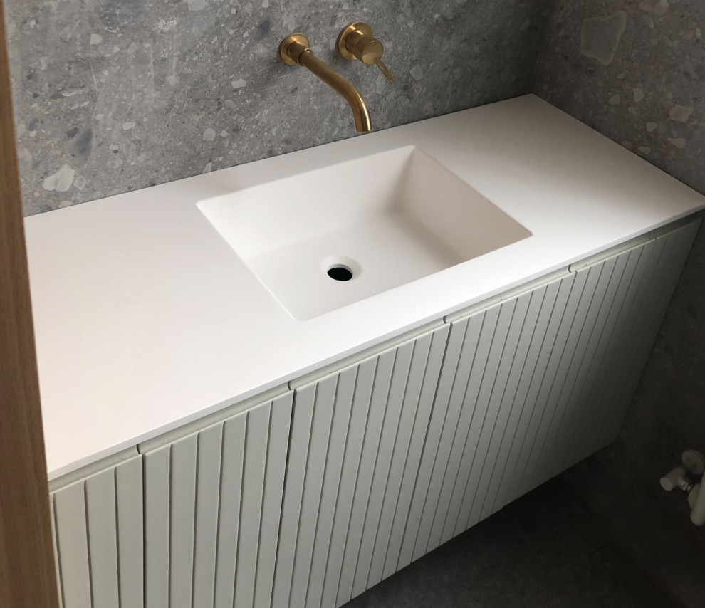 Bild på ett litet minimalistiskt vit vitt en-suite badrum, med luckor med upphöjd panel, vita skåp, våtrum, en toalettstol med separat cisternkåpa, grå kakel, grå väggar, klinkergolv i porslin, ett integrerad handfat, bänkskiva i kvarts, grått golv och dusch med skjutdörr