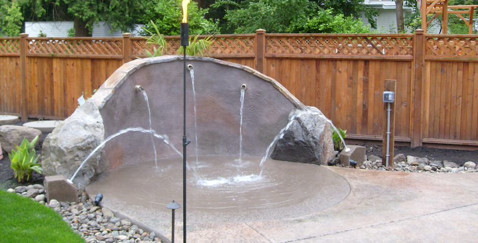 Large traditional backyard shaded garden in Portland with a water feature and concrete pavers.