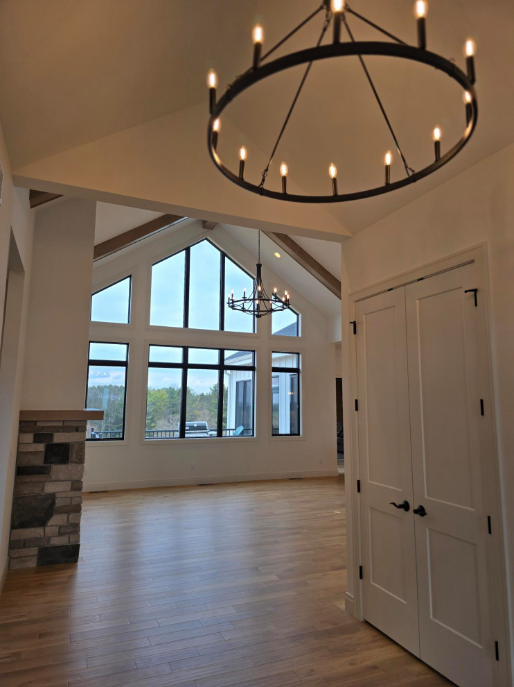 Transitional vinyl floor, brown floor and exposed beam entryway photo with white walls