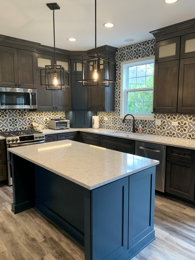 Photo of a mid-sized transitional u-shaped open plan kitchen in Chicago with an undermount sink, flat-panel cabinets, grey cabinets, quartz benchtops, multi-coloured splashback, cement tile splashback, stainless steel appliances, vinyl floors, with island, grey floor and white benchtop.
