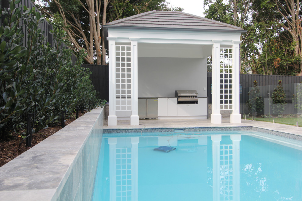 Inspiration for a contemporary backyard rectangular lap pool in Brisbane with a pool house and natural stone pavers.