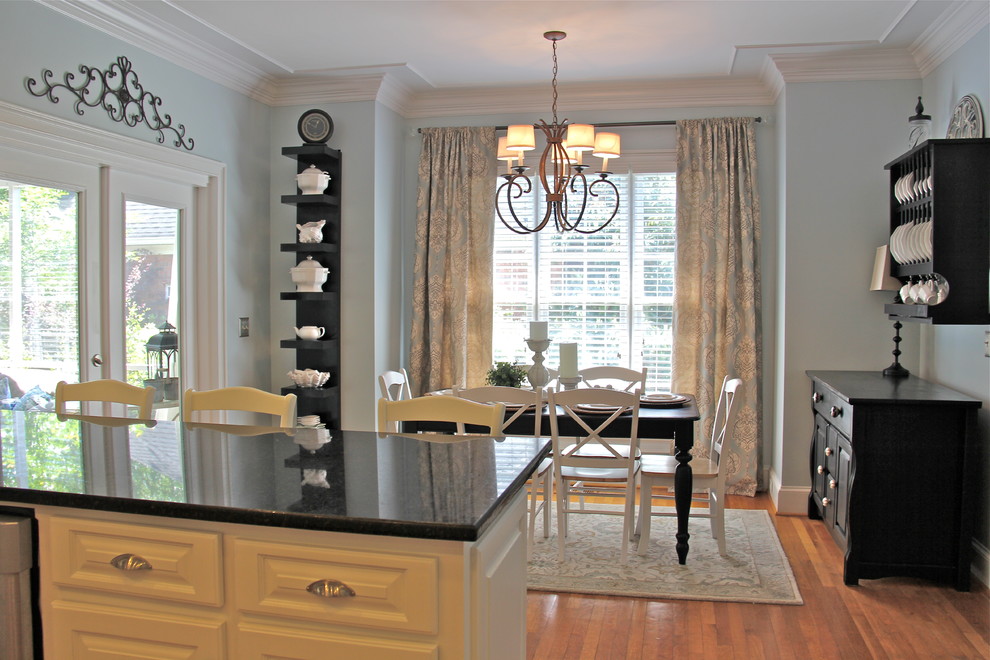 Mid-sized beach style u-shaped medium tone wood floor enclosed kitchen photo with raised-panel cabinets, white cabinets, granite countertops, white backsplash, subway tile backsplash, stainless steel appliances and an undermount sink
