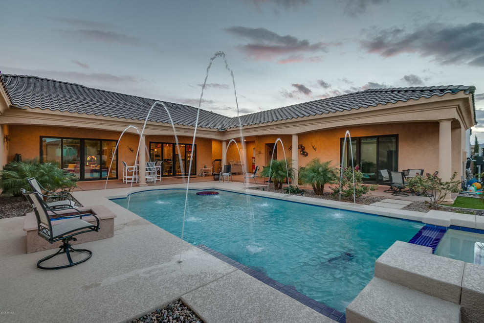 Large transitional backyard concrete and rectangular lap pool fountain photo in Phoenix