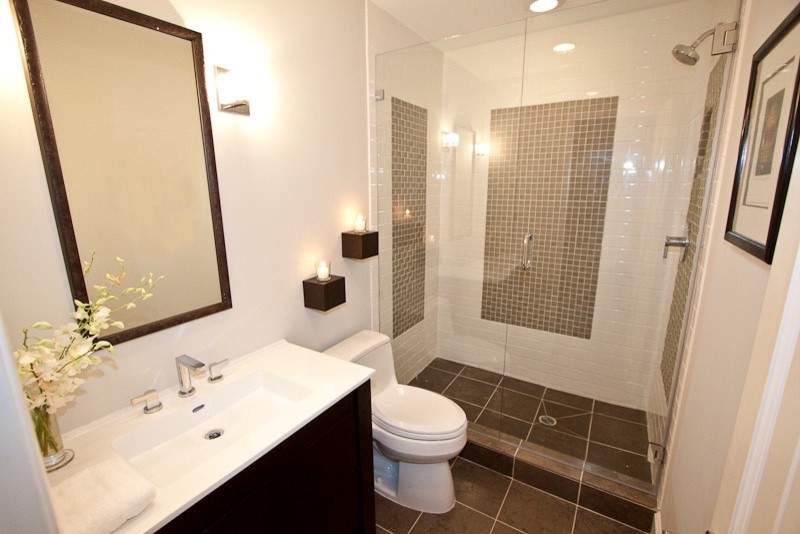 Inspiration for a small contemporary 3/4 bathroom in Los Angeles with flat-panel cabinets, dark wood cabinets, an alcove shower, a one-piece toilet, beige tile, white tile, subway tile, beige walls, ceramic floors, an integrated sink, engineered quartz benchtops, brown floor and a hinged shower door.