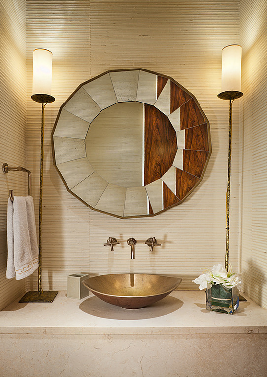 This is an example of a mid-sized transitional powder room in New York with open cabinets, beige cabinets, a two-piece toilet, beige tile, limestone, beige walls, limestone floors, a vessel sink, marble benchtops, beige floor and beige benchtops.