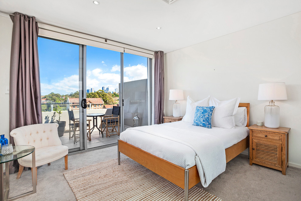 Small transitional master bedroom in Sydney with white walls and carpet.