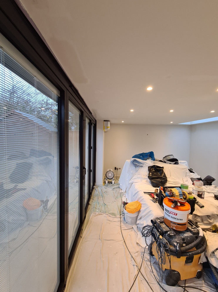 Ejemplo de dormitorio principal minimalista grande con paredes blancas, suelo de baldosas de porcelana, suelo beige y bandeja