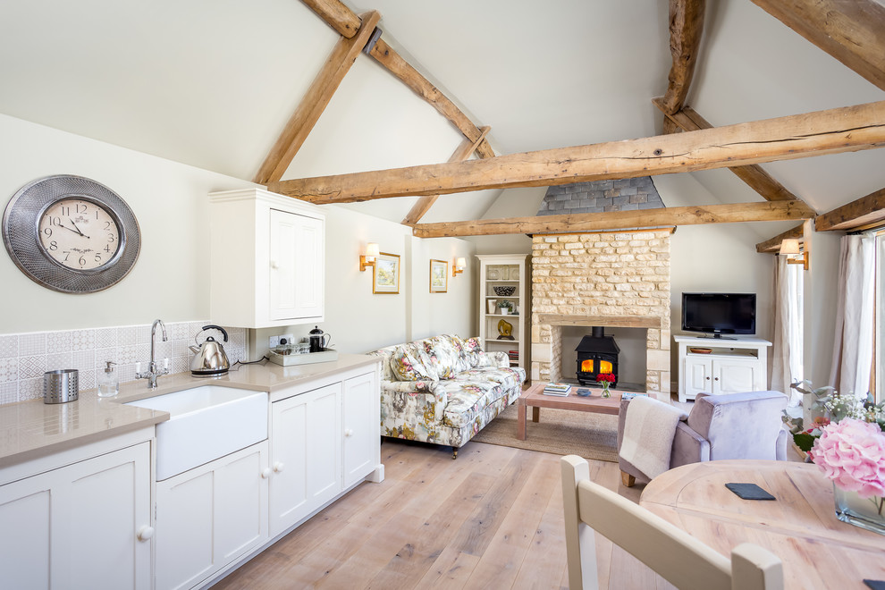 Inspiration for a large country open plan kitchen in Gloucestershire with light hardwood floors, a farmhouse sink, shaker cabinets, beige cabinets, granite benchtops, beige splashback, ceramic splashback and no island.
