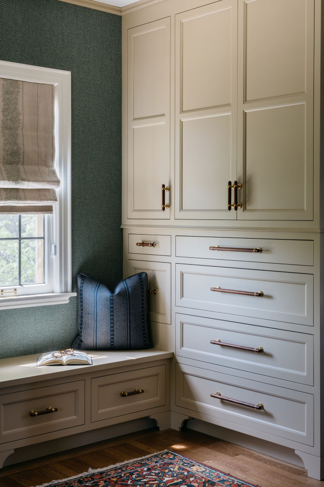 This is an example of a medium sized traditional built-in wardrobe in Milwaukee with shaker cabinets, white cabinets, medium hardwood flooring and brown floors.