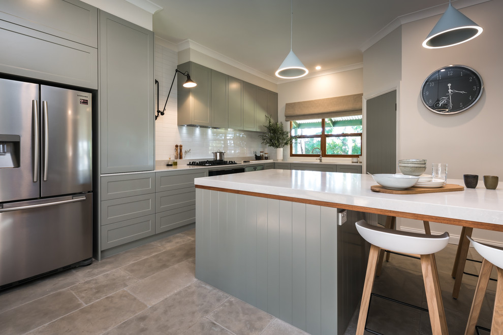 Large contemporary l-shaped open plan kitchen in Adelaide with grey cabinets, white splashback, subway tile splashback, stainless steel appliances, terra-cotta floors, with island, white benchtop, an undermount sink, grey floor, shaker cabinets and quartz benchtops.