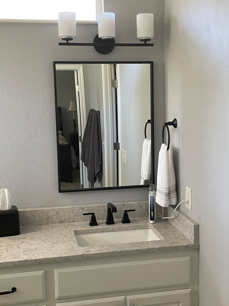 This is an example of a large master bathroom in Austin with raised-panel cabinets, white cabinets, an alcove shower, a two-piece toilet, white tile, porcelain tile, grey walls, porcelain floors, an undermount sink, grey floor, a hinged shower door, grey benchtops, a niche, a double vanity and a built-in vanity.