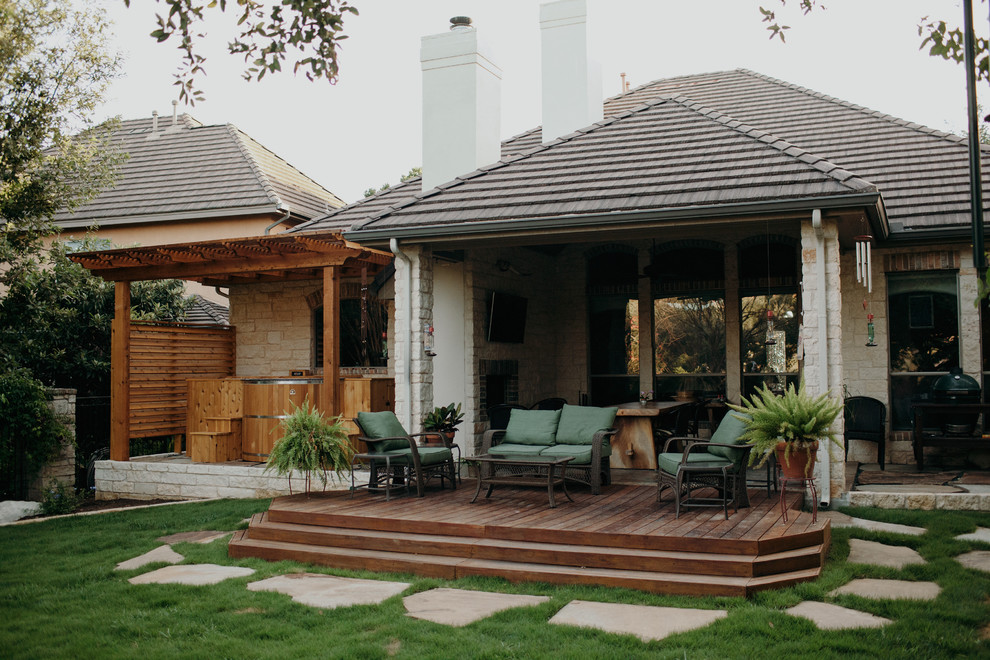 This is an example of a mid-sized traditional backyard formal garden in Austin with decking.