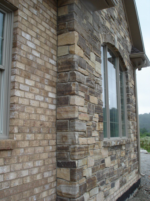 Arts and crafts two-storey exterior in Other with stone veneer.