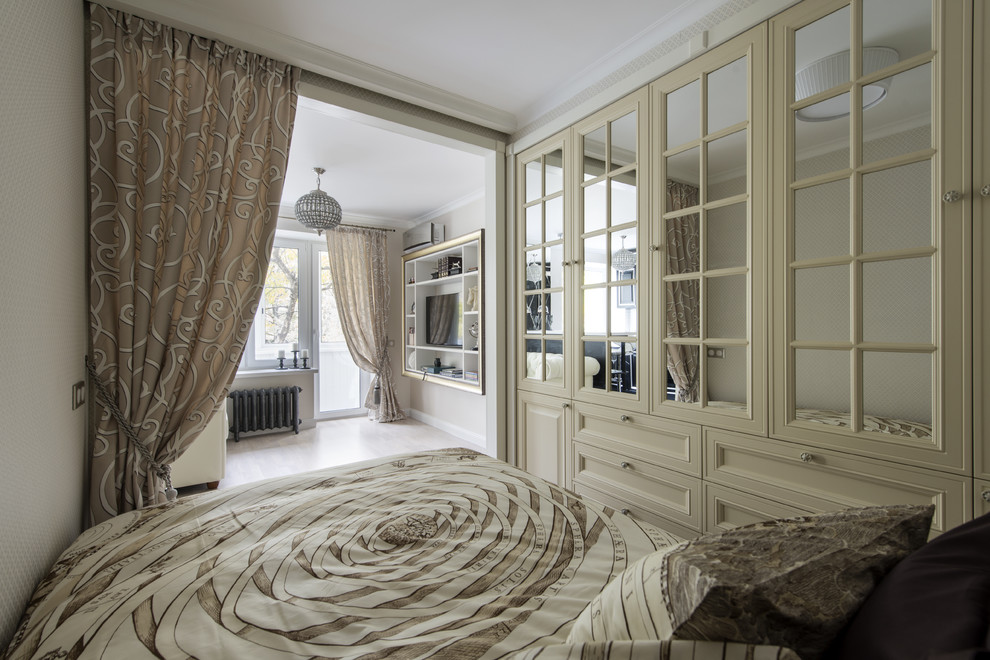 Inspiration for a traditional master bedroom in Moscow with white walls and light hardwood floors.