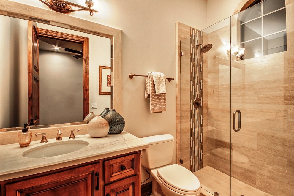 Mid-sized traditional bathroom in Phoenix with an undermount sink, raised-panel cabinets, medium wood cabinets, granite benchtops, an open shower, a one-piece toilet, beige tile, glass tile, beige walls and travertine floors.